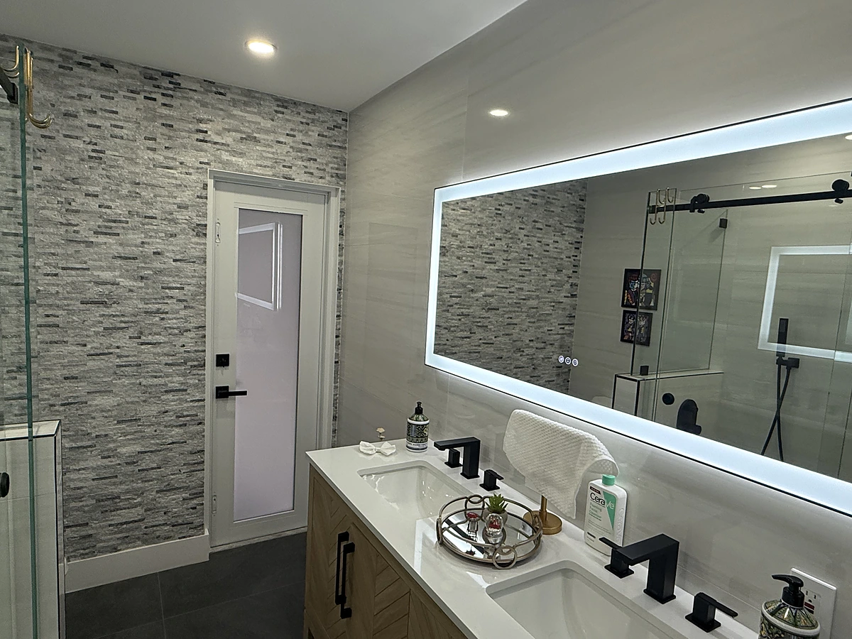 Double vanity with a wide backlit LED mirror and mosaic accent wall