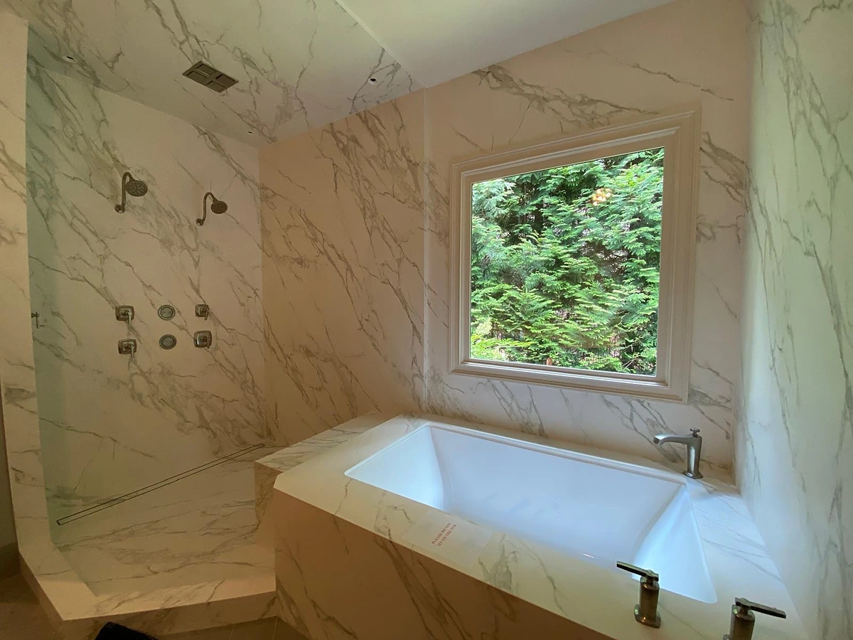 Drop-in soaking tub with full marble surround and picture window