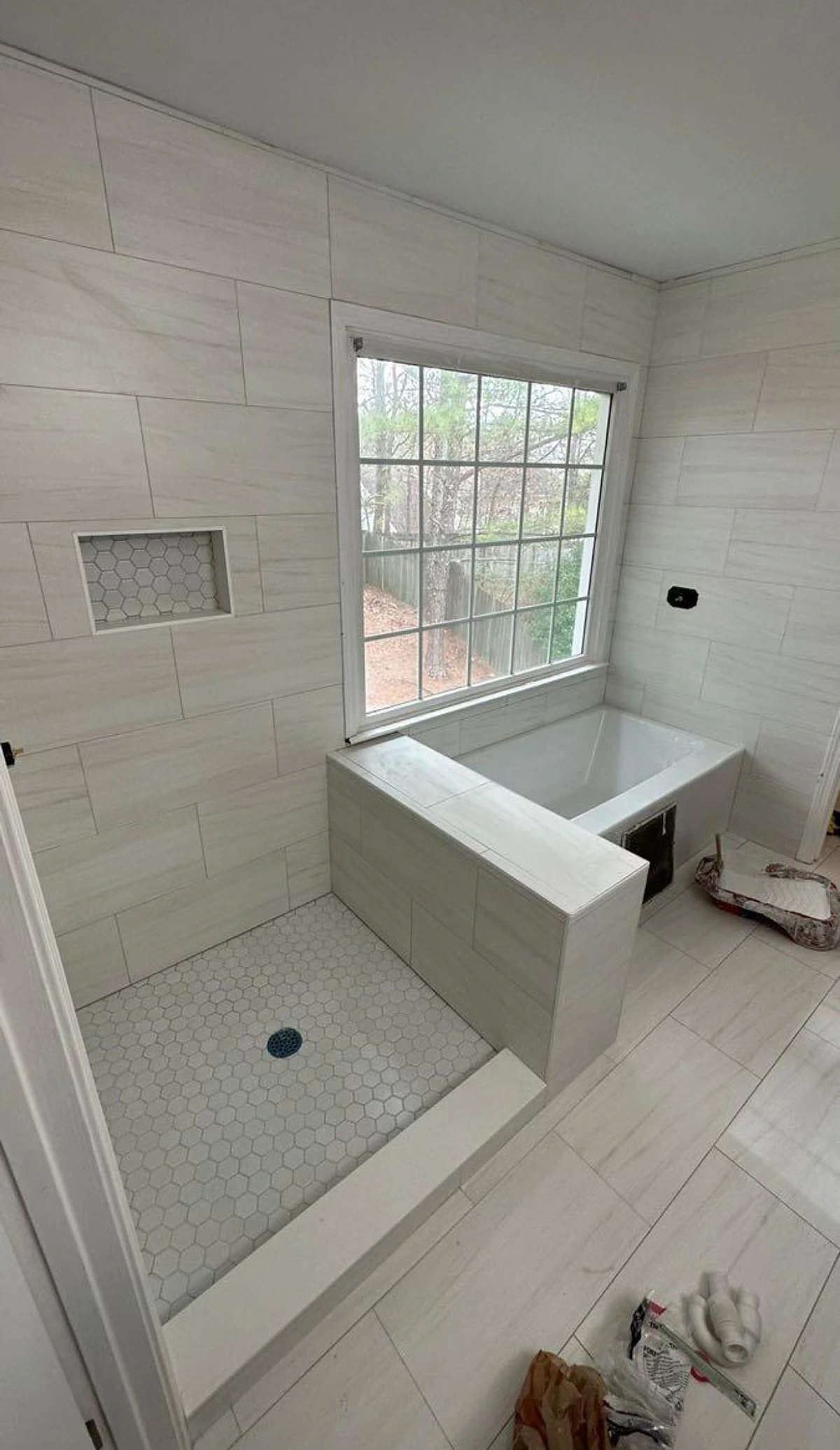 Drop-in tub with tiled surround, window and shower niche