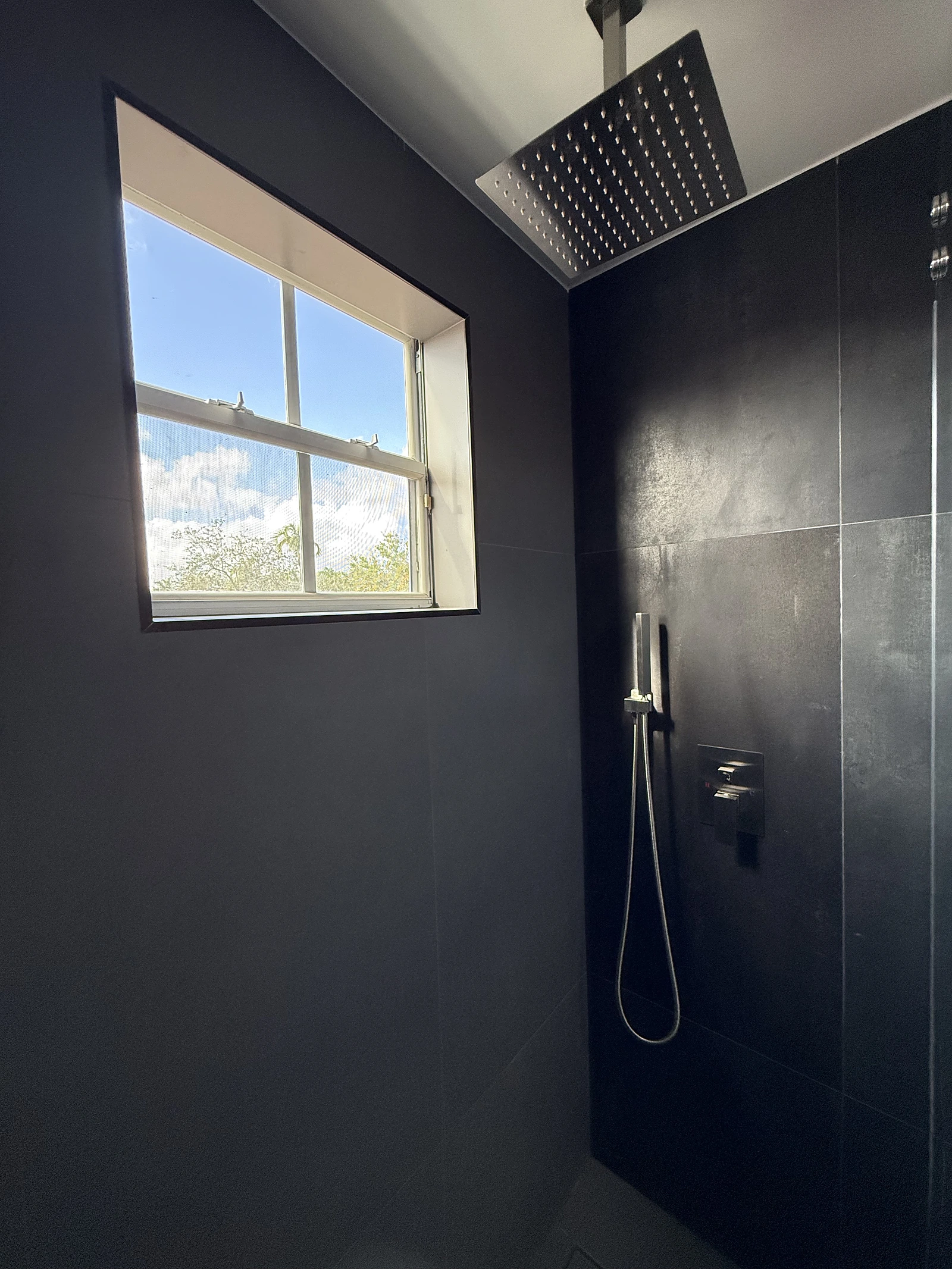 Dramatic black tile shower with rain head and window — Pompano Beach, FL