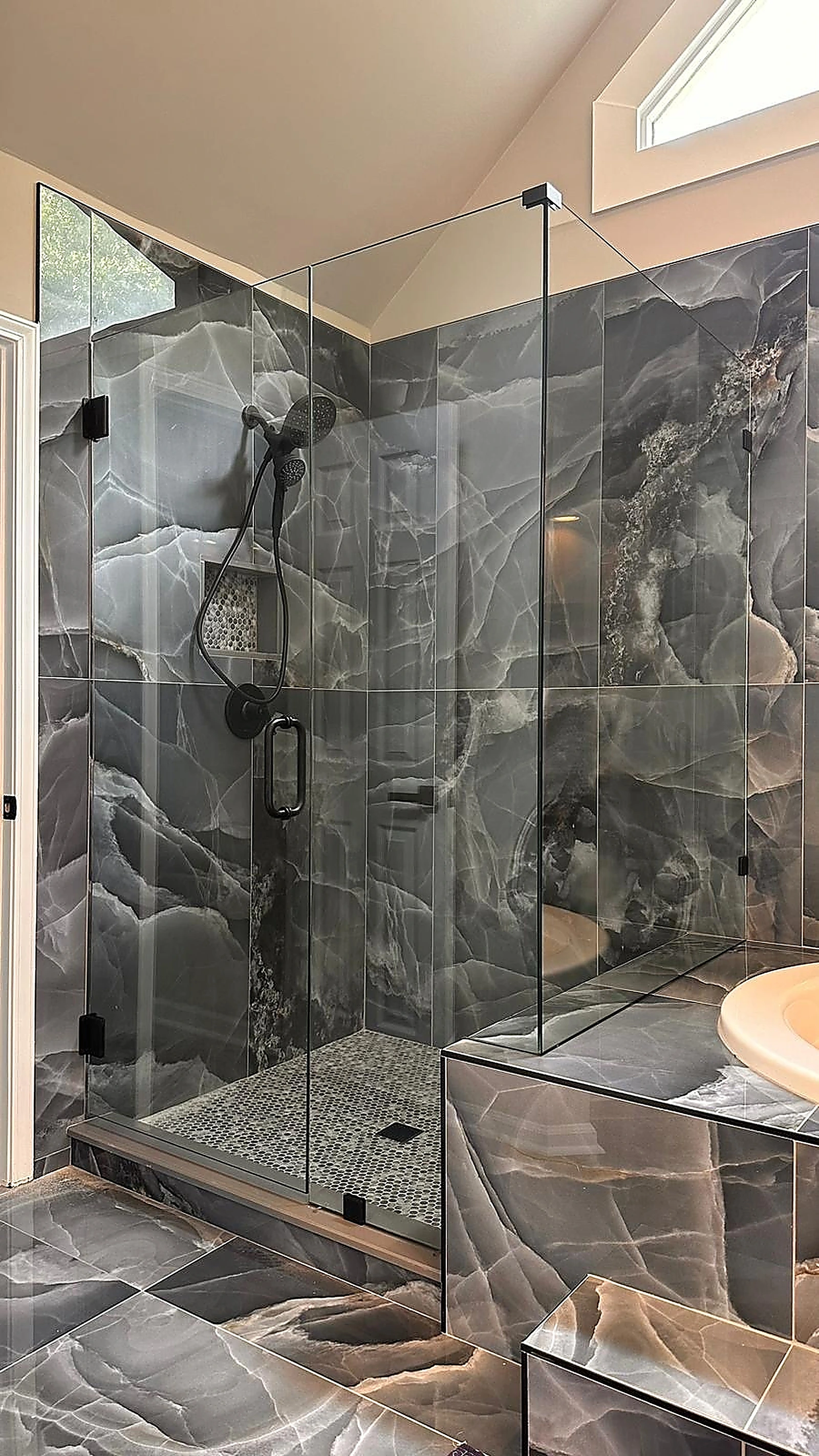 Glass shower with dark veined marble tile in a South Florida remodel — Boynton Beach, FL