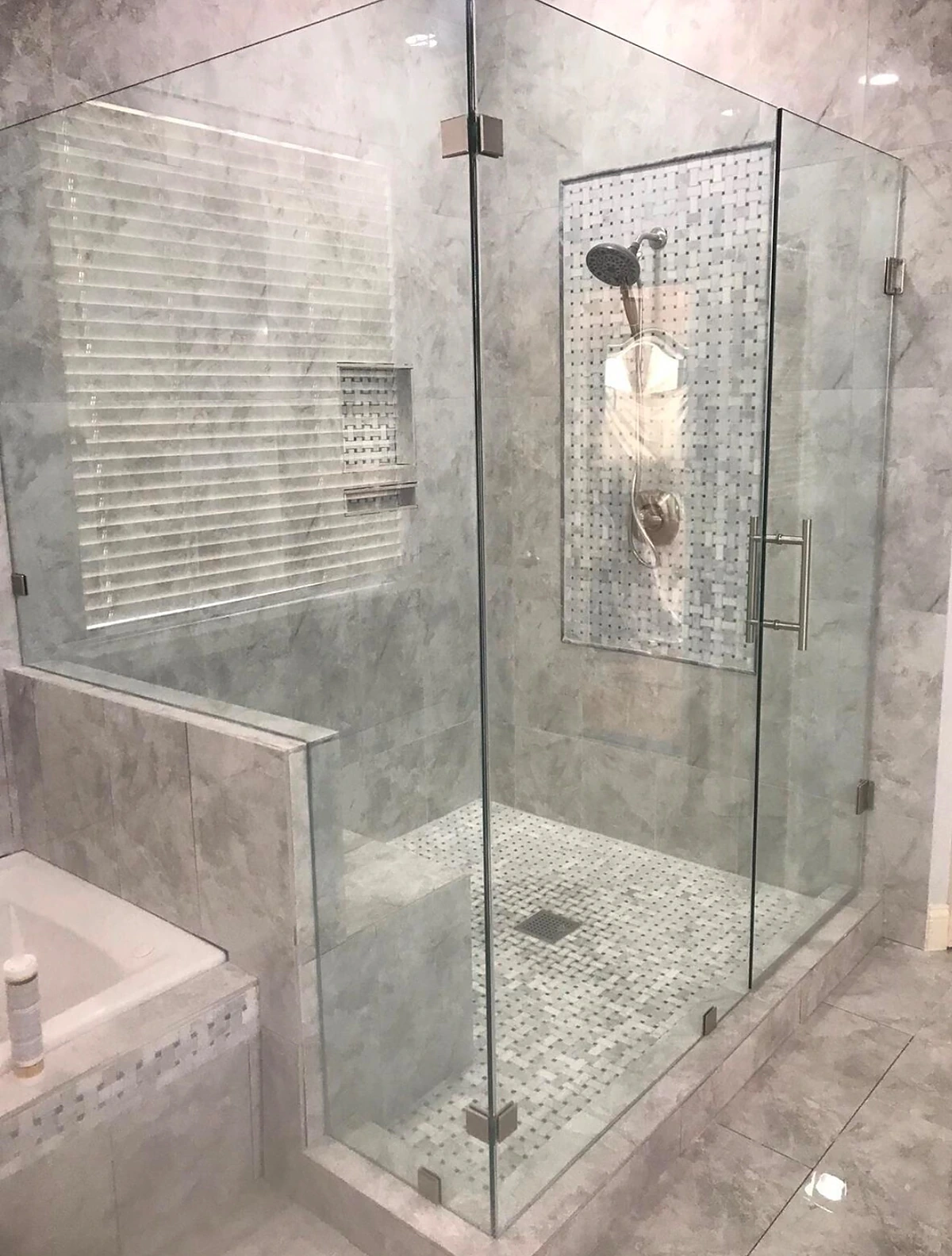 Glass shower enclosure beside a built-in soaking tub