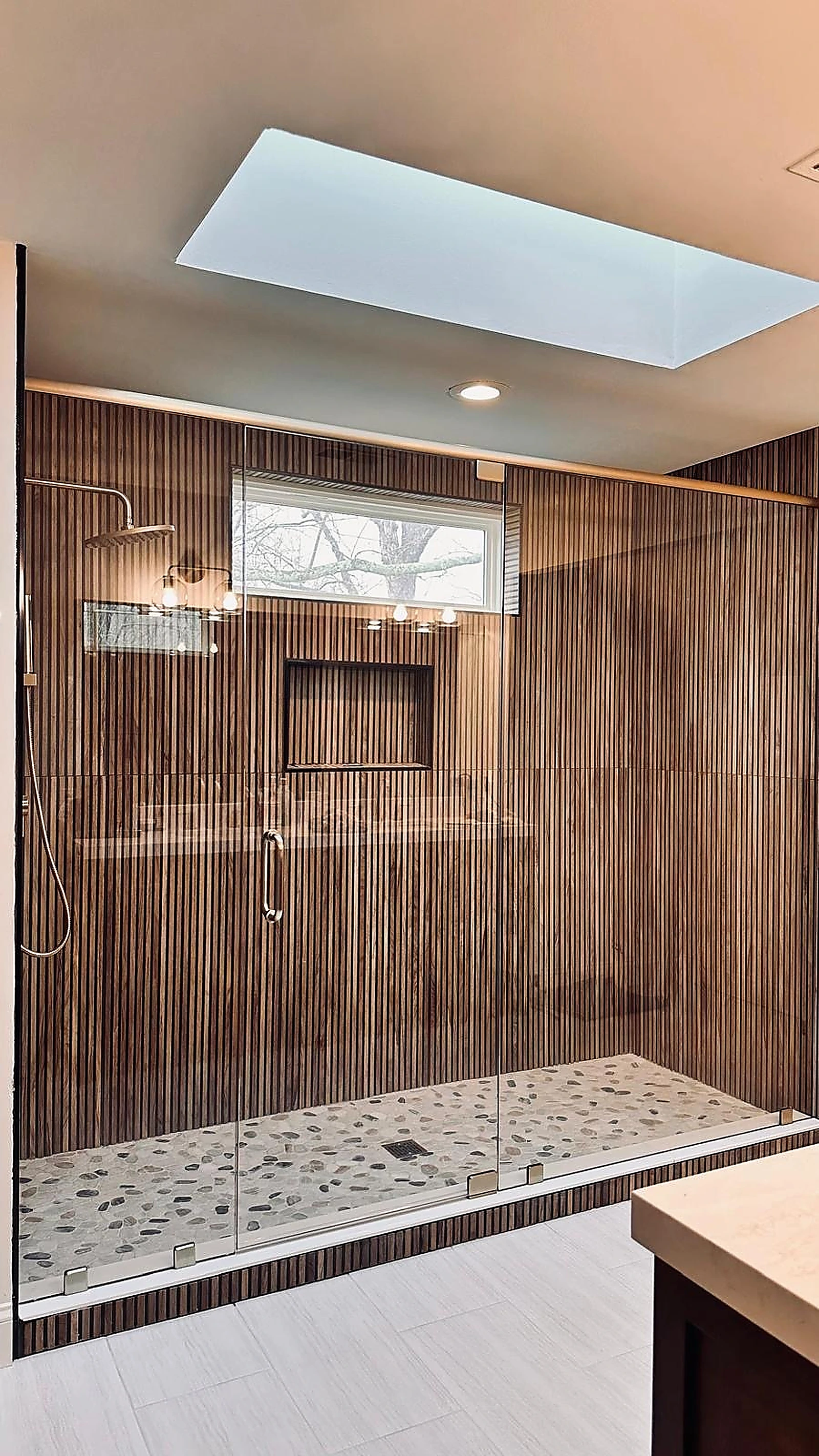 Wide walk-in shower in ribbed wood-look tile beneath a skylight — Boynton Beach, FL