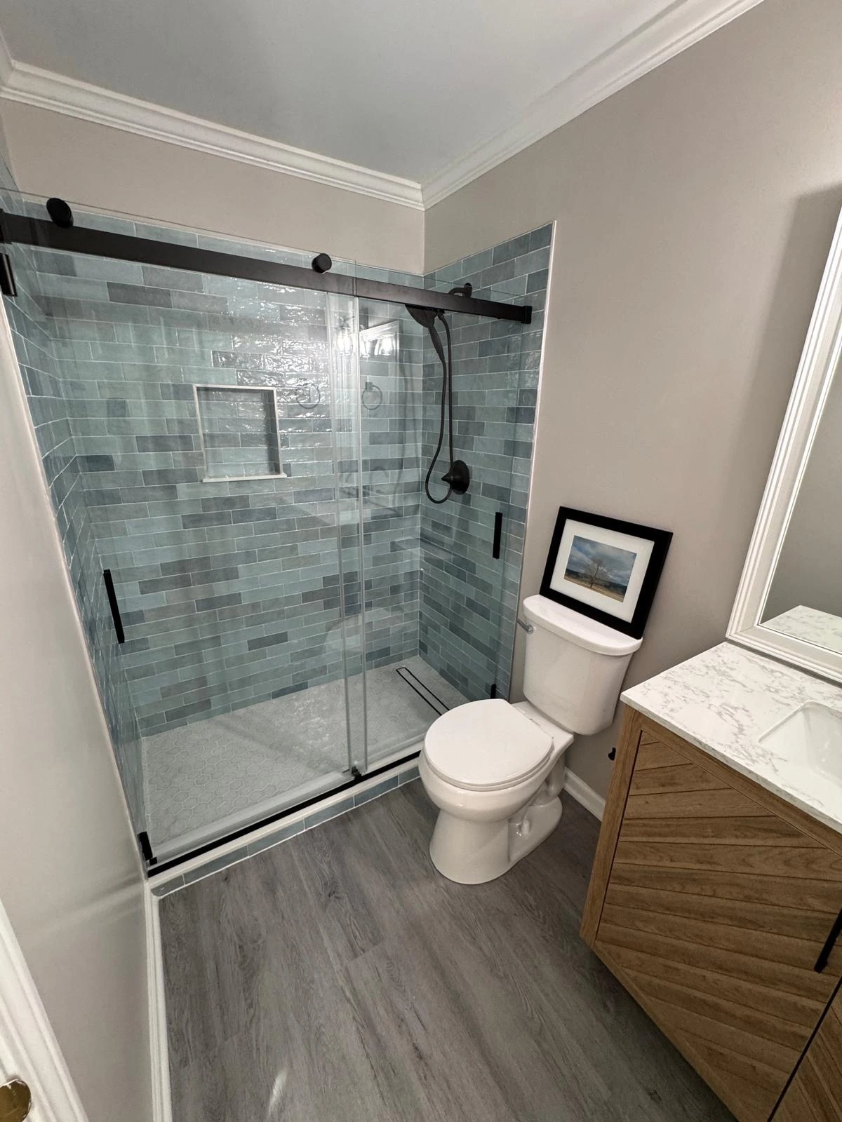 Sliding glass shower with teal tile and a wood floating vanity — Deerfield Beach, FL