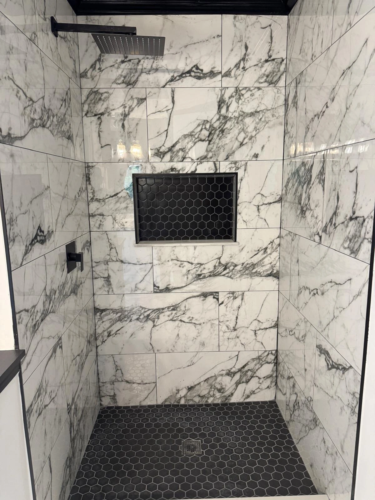 White marble shower with black hexagon pan and matte black fixtures — Boynton Beach, FL