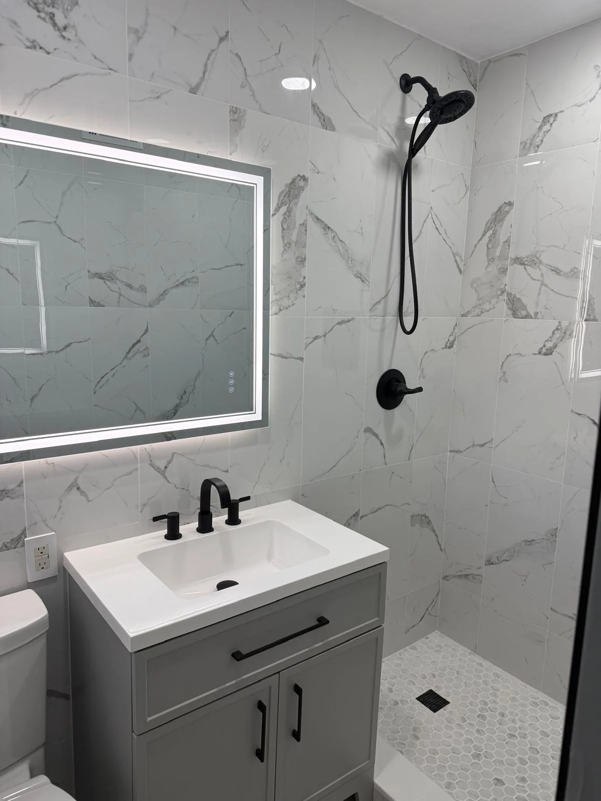 Modern floating bathroom vanity with vessel sink and LED mirror in South Florida bathroom remodel